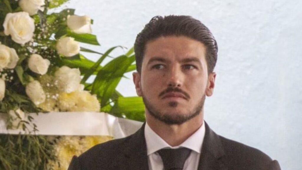 Man in a Black Suit and White Shirt Wearing a Black Tie, Standing Next to a Large Arrangement of White Roses Indoors. - La Razón Nl