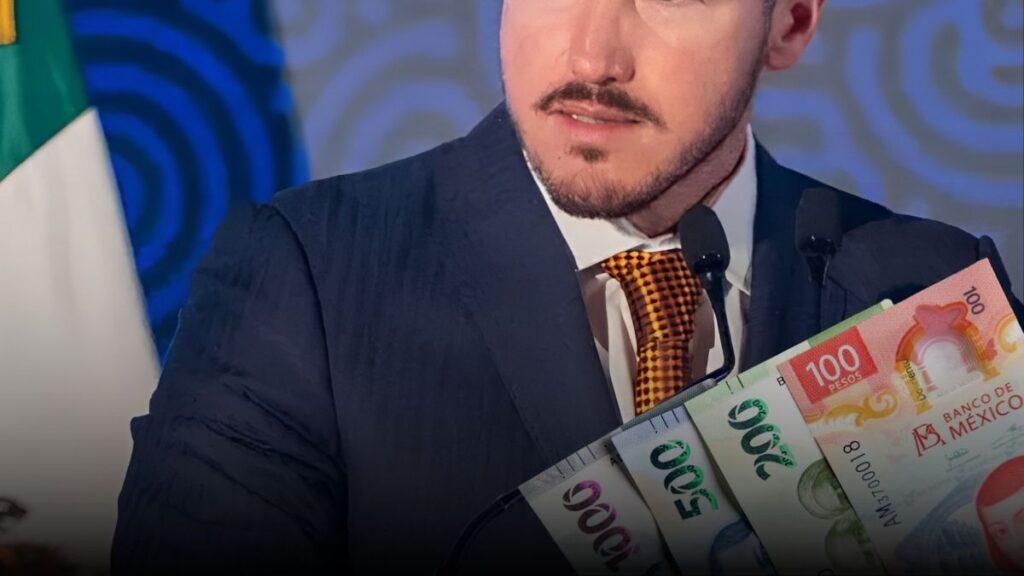 Man in a Dark Suit and Orange Checkered Tie Speaks at a Podium with Two Microphones, While Colorful Mexican Banknotes Are Fanned Up in the Foreground. - La Razón Nl