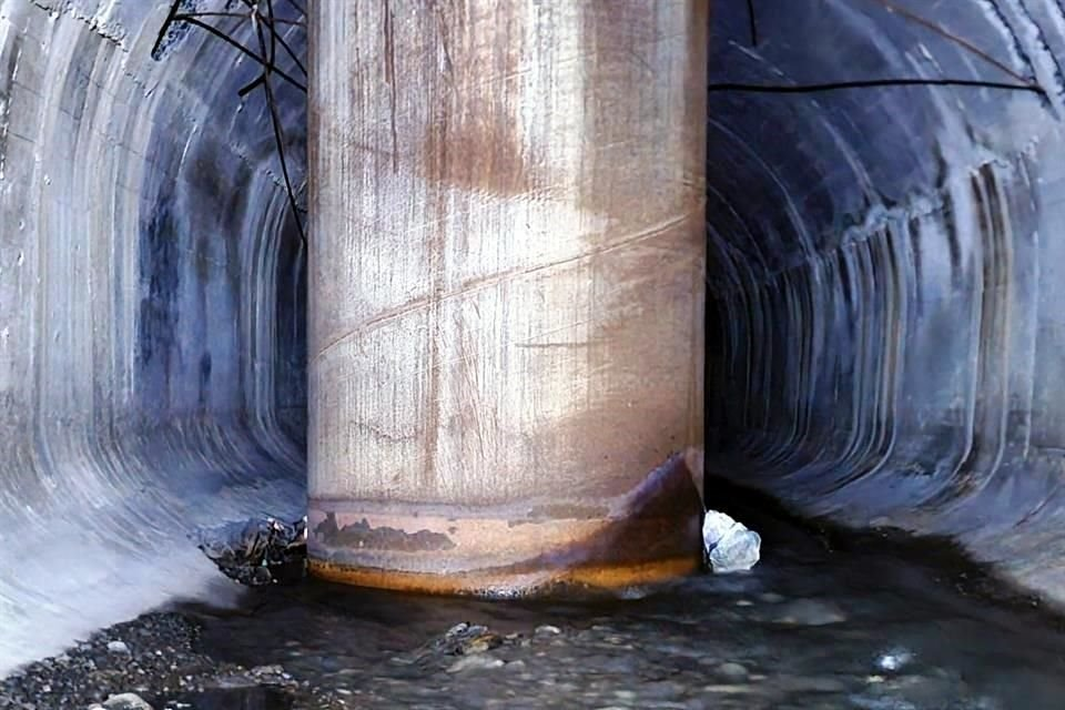 Image - La Razón Nl a Cylindrical Concrete Tunnel with Ribbed Walls and a Tall Central Pillar, Water Pooling Around Its Base and Rusty Ring at the Bottom Edge, Barbed Wire Overhead Behind. - La Razón Nl