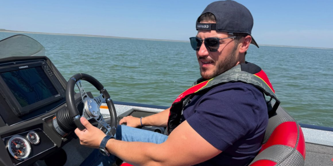 Gira En Austin Esconde Paseo Familiar De Samuel. - La Razón Nl Man Wearing a Backward Cap and Sunglasses Steering a Motorboat on Calm Water Under a Clear Sky. - La Razón Nl