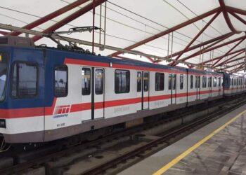 Blue and White Commuter Train with a Red Stripe at a Platform Under a Red Steel Canopy - La Razón Nl