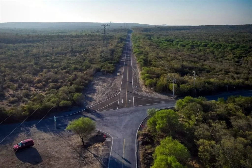 Image - La Razón Nl Aerial View of a Rural Intersection Where a Roadway Splits and Continues Straight into a Long, Distant Road, with Power Lines Along the Sides and a Red Car Parked at a Roadside Corner on the Left. - La Razón Nl